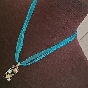 Silvertone geometric pendant with blue, green stones on turquoise cord necklace